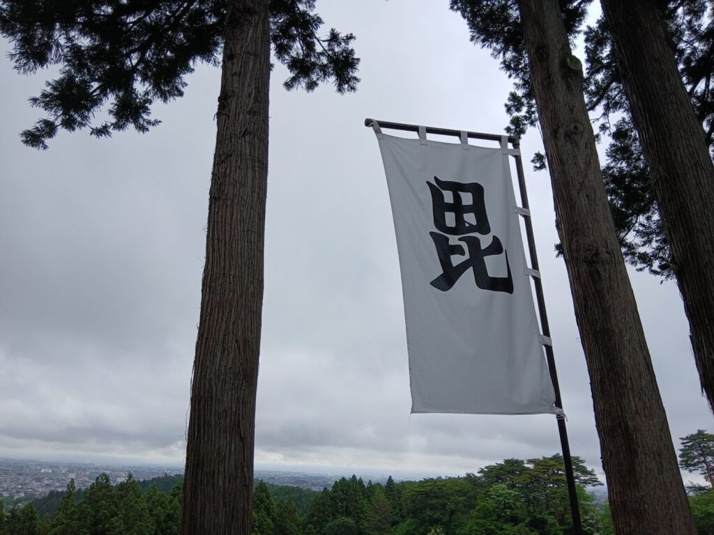 春日山城跡にひるがえる「毘」の旗